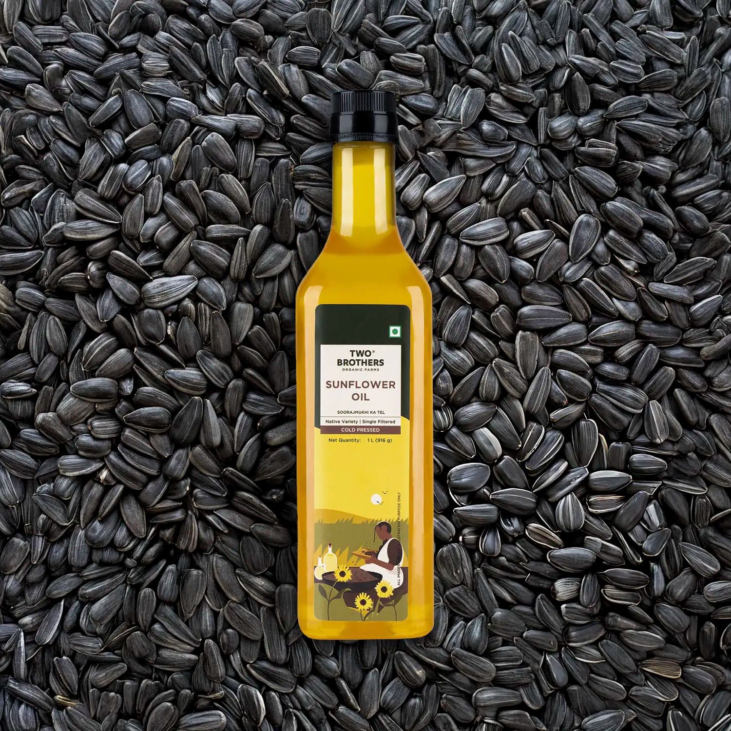 A clear bottle of cold-pressed sunflower oil placed on a background of raw sunflower seeds.