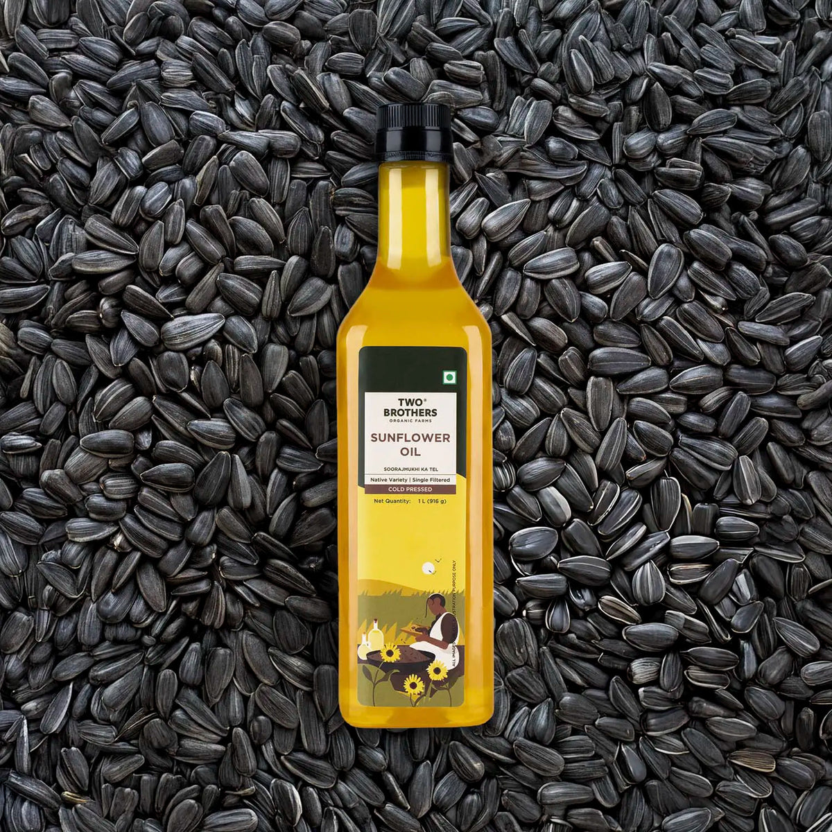 A clear bottle of cold-pressed sunflower oil placed on a background of raw sunflower seeds.