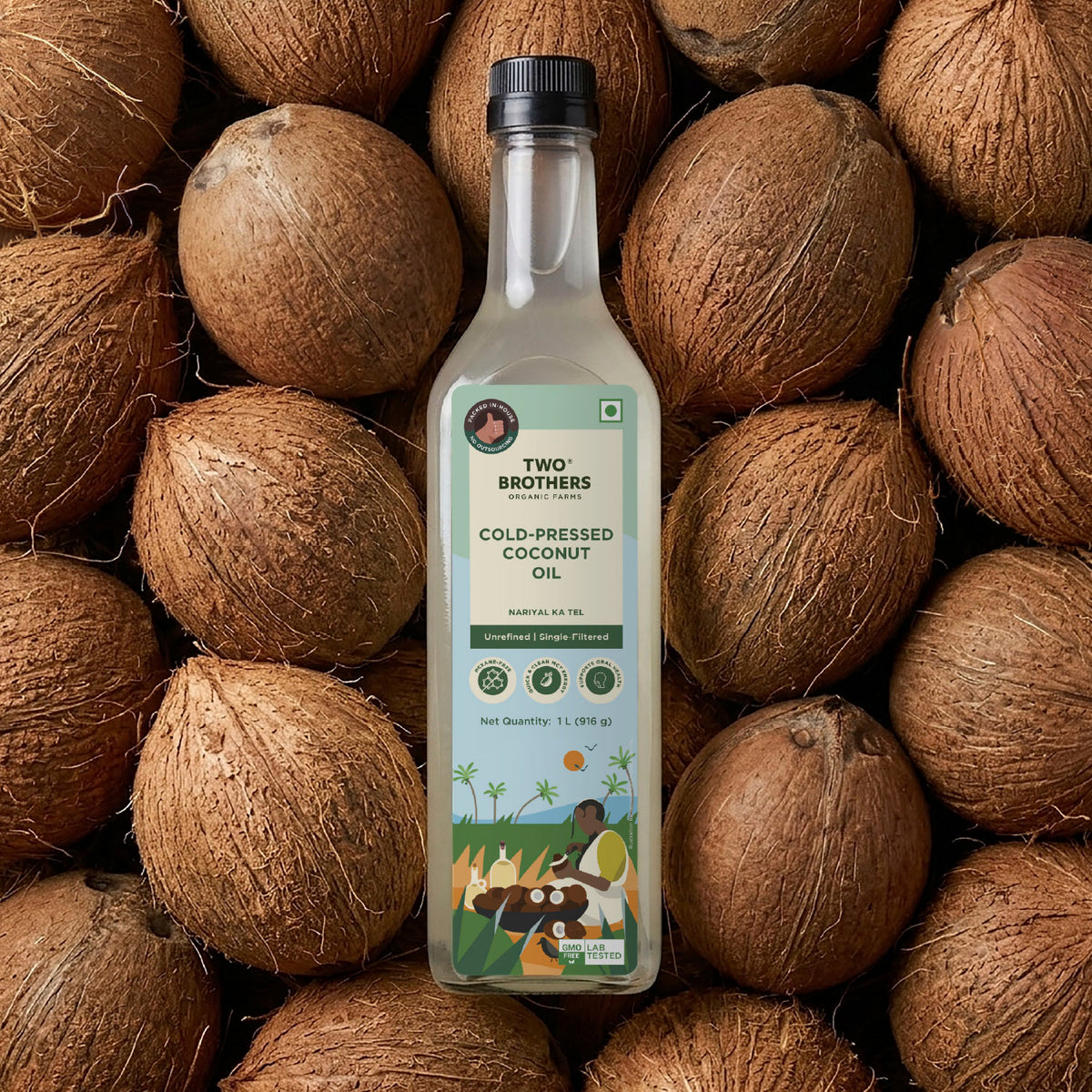 Two Brothers Organic Farms unrefined cold-pressed coconut oil 1L glass bottle styled over a background of raw whole coconuts.